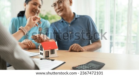 Ownership and New home,retirement concept.real estate agent give keys to new home to excited asia elderly couple clients.Asian Woman realtor or broker congratulate happy overjoyed with house purchase.