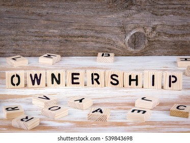 Ownership from wooden letters on wooden background