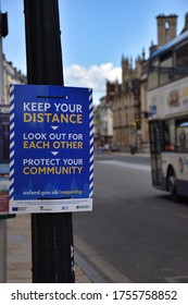 Oxford, UK- 06 13 2020: Oxford Introduces Social Distancing To The City Centre Streets. Signaling Business Are Open With Pavement Markings And Street Signs. A Bus Passes A Sign In High Street