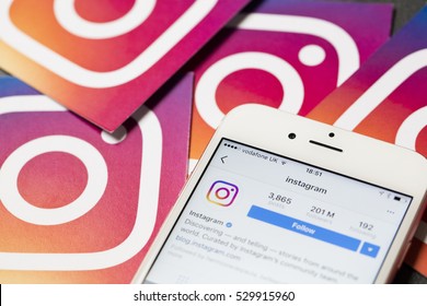 OXFORD, UK - DECEMBER 5th 2016: An apple iPhone showing the instagram application alongside other instagram printed logos. Instagram is a popular social media application for sharing images and videos