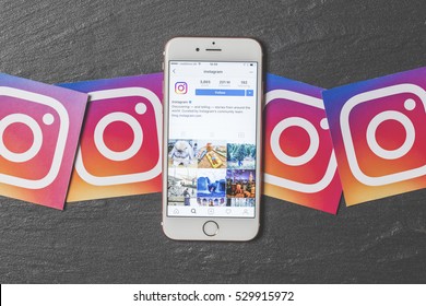 OXFORD, UK - DECEMBER 5th 2016: An apple iPhone showing the instagram application alongside other instagram printed logos. Instagram is a popular social media application for sharing images and videos