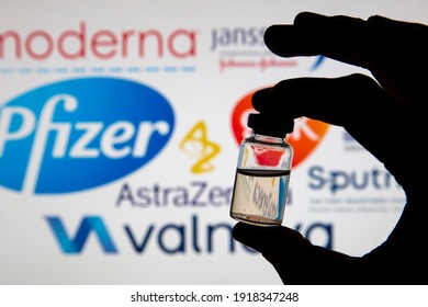 OXFORD, UK - February 2020: Vaccine Dose Bottle Infront Of Covid Vaccine Logos