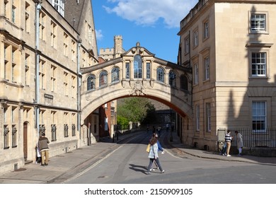 Oxford, United Kingdom - April 15, 2022: People walking across the street near the Bridge of Sighs; a skyway connecting two parts of Hertford College.