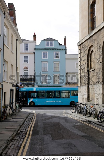 Oxford, United Kingdom - March, 2020: Grand cafe,\
Antique on High and other shops in high street. Small atmospheric\
street in Oxford with blue bus.\
