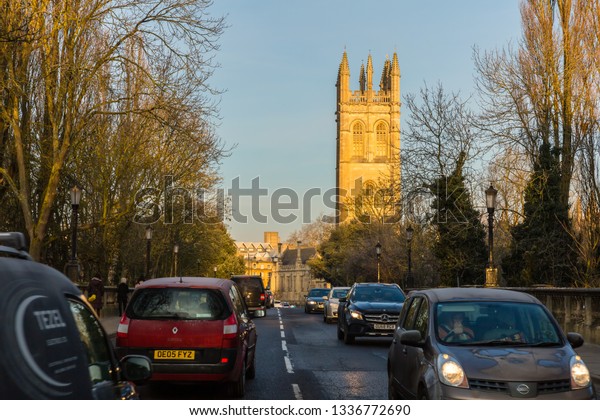 Oxford/UK -\
Feb 2019: traffic on Magdalen Bridge which runs over the River\
Cherwell and Magdalen Great Tower in\
Oxford