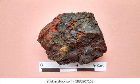 Oxidized Mineral Iron Ore Samples Are Black And Reddish. For Metal Rock Identification, On A Pink Background, From Indonesia.