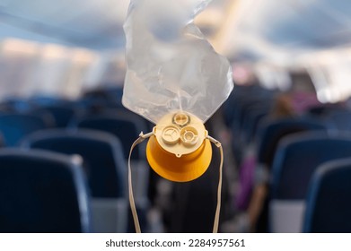 oxygen mask drop from the ceiling compartment on airplane	 - Shutterstock ID 2284957561