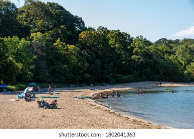 OYSTER BAY, NY USA - AUGUST 23 2020: Bathers in the afternoon sun on Beekman Beach in Oyster Bay, New York