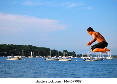 Oyster Bay, NY, USA June 30  A Child Soars Into The Air, Jumping Into The Waters Below On A Summer’s Day In Oyster Bay, New York