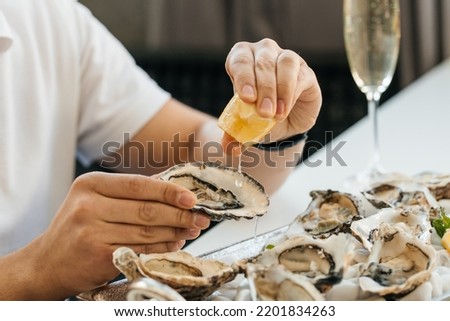 oyster. Man eating shellfish. Seafood and Mediterranean cuisine with mussels in shell. oyster in luxury restaurant. Foto d'archivio © 