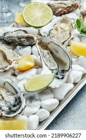 Oysters On The Half Shell. Fresh Oysters Served With Cocktail Sauce And Fresh Lemons. Oyster Dinner In Restaurant.