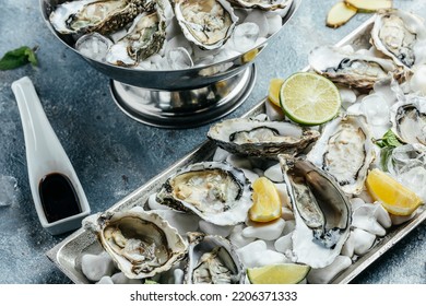 Oysters On The Half Shell. Fresh Oysters Served With Cocktail Sauce And Fresh Lemons. Oyster Dinner In Restaurant.