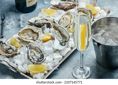 Oysters with wine, lemon, and ice. oysters dish. Oyster dinner with champagne in restaurant. banner, menu, recipe place for text, top view. - Shutterstock ID 2107145771