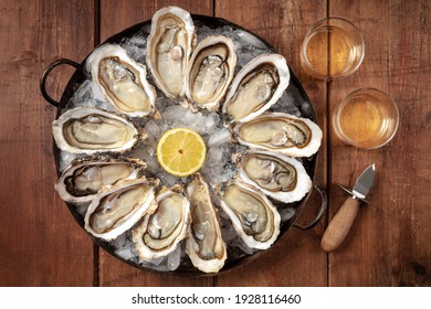 Oysters with wine, lemon, and a shucking knife, overhead flat lay shot on a rustic background