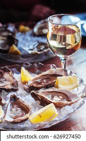 Oysters and wine. Oysters on ice with lemon. Seafood and white wine.
