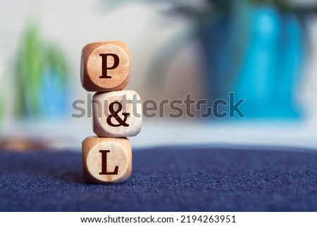 P and L (profit and loss) acronym on wooden cubes on dark wooden background. Business concept. Stock fotó © 