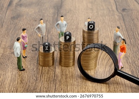 I P O blocks on stack of coins and magnifying glass Concept of Initial public offering