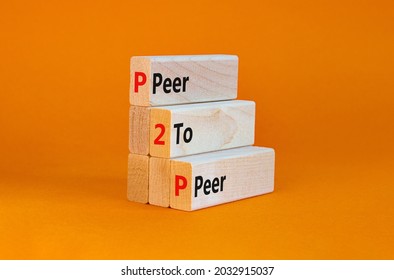 P2P,  peer symbol. Wooden blocks with concept words 'P2P, peer to peer'. Beautiful orange background, copy space. Business and P2P, peer to peers concept.