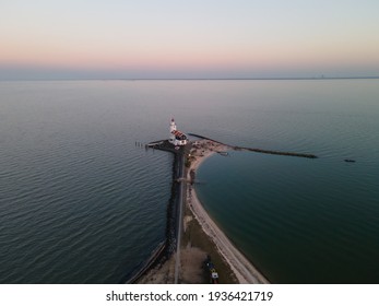 Paard van Marken, lighthouse at sun set along the water in the Netherlands, near Amsterdam in Marken. Aerial drone view.