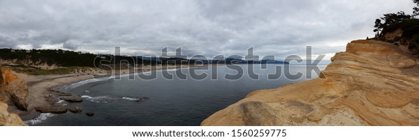 Pacific City, Oregon Coast, United States\
of America. Beautiful Panoramic View of a small touristic town on\
the Ocean Coast during a cloudy summer\
evening.