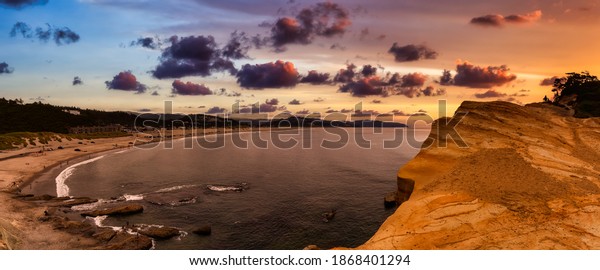 Pacific City, Oregon Coast, United\
States of America. Beautiful Panoramic View of a small touristic\
town on the Ocean Coast. Dramatic Colorful Sunset\
Sky.