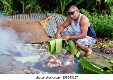 Pacific Islander Adult Man Preparing Local  Food Cooking In Earth Oven, Umu, At The Early Stage Of Heating The Rocks Underground.