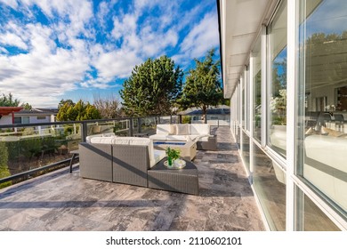 Pacific Northwest Backyard And Spacious Deck Bright Sunny Day With Blue Skies Fire Pit Fireplace White Adirondack Chairs Green Grass Fenced Family Home