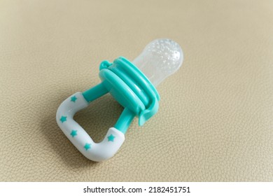 Pacifier For Baby Blue Color On Faux Leather Background.