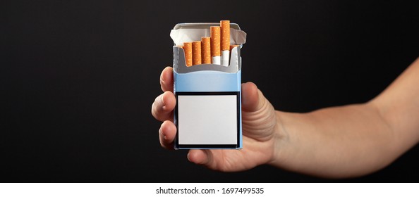 Pack Of Cigarettes In Hand On Dark Background. Cigarette Ad.