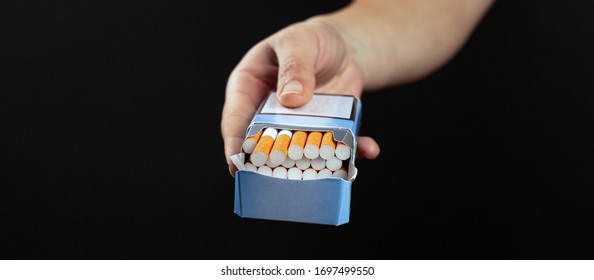 Pack Of Cigarettes In Hand On Dark Background. Cigarette Ad.