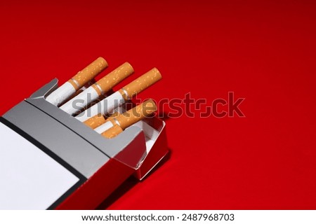 A pack of cigarettes on a red background