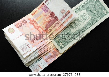 pack of five thousandth rubles and one dollar on a black background