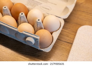 A pack of fresh eco free range farm eggs in the kitchen up close, detail shot, carton egg box container on a wooden table, closeup, nobody, no people Healthy eating, natural ingredients simple concept