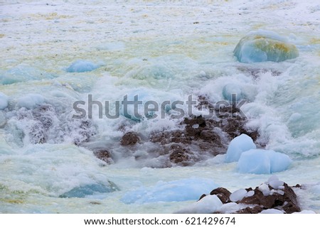 Pack ice rolling over rocks.