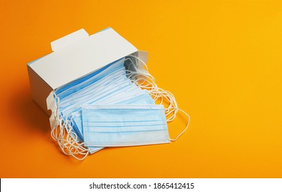 Pack Of Medical Masks In Box. Anti Virus And Bacteria Protective Face Air Pollution, Protection Concept. On A Orange Background.