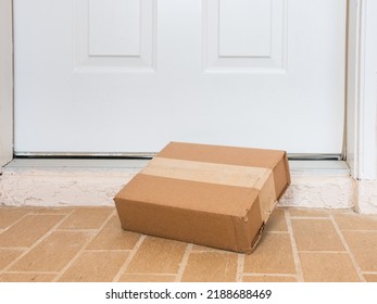 Package Box Delivered To A Residential Doorstep. Online Order Package Delivery To The Front Porch Of Home.