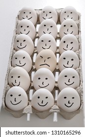 Package of bright backlit eggs with smiling faces except for one grumpy sad face - Shutterstock ID 1310165296