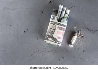 Package of cigarette filled with paper money dollars banknote instead of cigarette sticks and Cigarette butt.  Smoking is bad for your health, actually burning / wasting money .Copy space.