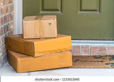 Package delivery on doorstep. Boxes and postal delivery on modern brick home doorstep on front with 3 cardboard boxes