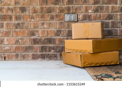 Package delivery on doorstep. Boxes and postal delivery on modern brick home doorstep on front side view next to brick wall on home