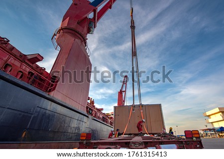 Package unit of the heavy life cargo being discharging or loading by the ship crane under supervisor by professional handling in the port terminal