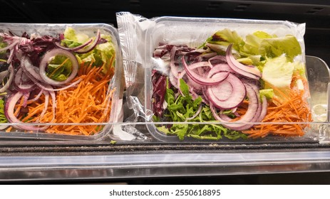 Packaged fresh salad mix with vibrant vegetables on a supermarket shelf, promoting healthy eating and convenience for busy lifestyles - Powered by Shutterstock