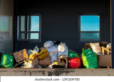 Packaged waste for landfilling. Garbage bags and boxes on the loading dock. Garbage removal.