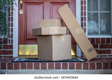 Packages at risk for theft stacking up on the porch of a suburban residence due to the great increase in online purchasing.