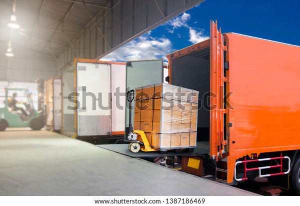 Packaging Boxes on Pallet Loading into\
Shipping Cargo Container. Delivery Trucks. Supply Chain. Trucks\
Parked Loading at Dock Warehouse. Shipment. Cargo Freight Truck\
Transport Logistics.