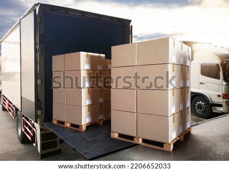 Packaging Boxes Stack on Pallets Loading into Cargo Container. Shipping Trucks. Supply Chain Shipment Boxes. Distribution Supplies Warehouse. Freight Truck Transport Warehouse Logistics.	
