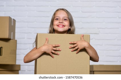 Packaging things. Move out concept. Delivering your purchase. Kid moving out. Moving routine. Prepare for moving. Rent house. Real estate. Make moving easier. Girl small child carry cardboard box.