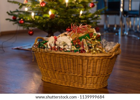 Packaging waste in a basket in front of the decorated chrismas tree