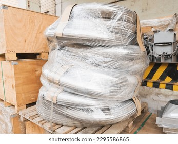 Packed metal hoses (metallic hoses) for transporting substances and media, wrapped in stretch film and ready for shipping.