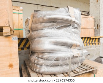 Packed metal hoses for transporting substances and media, wrapped in stretch film and ready for shipping.
